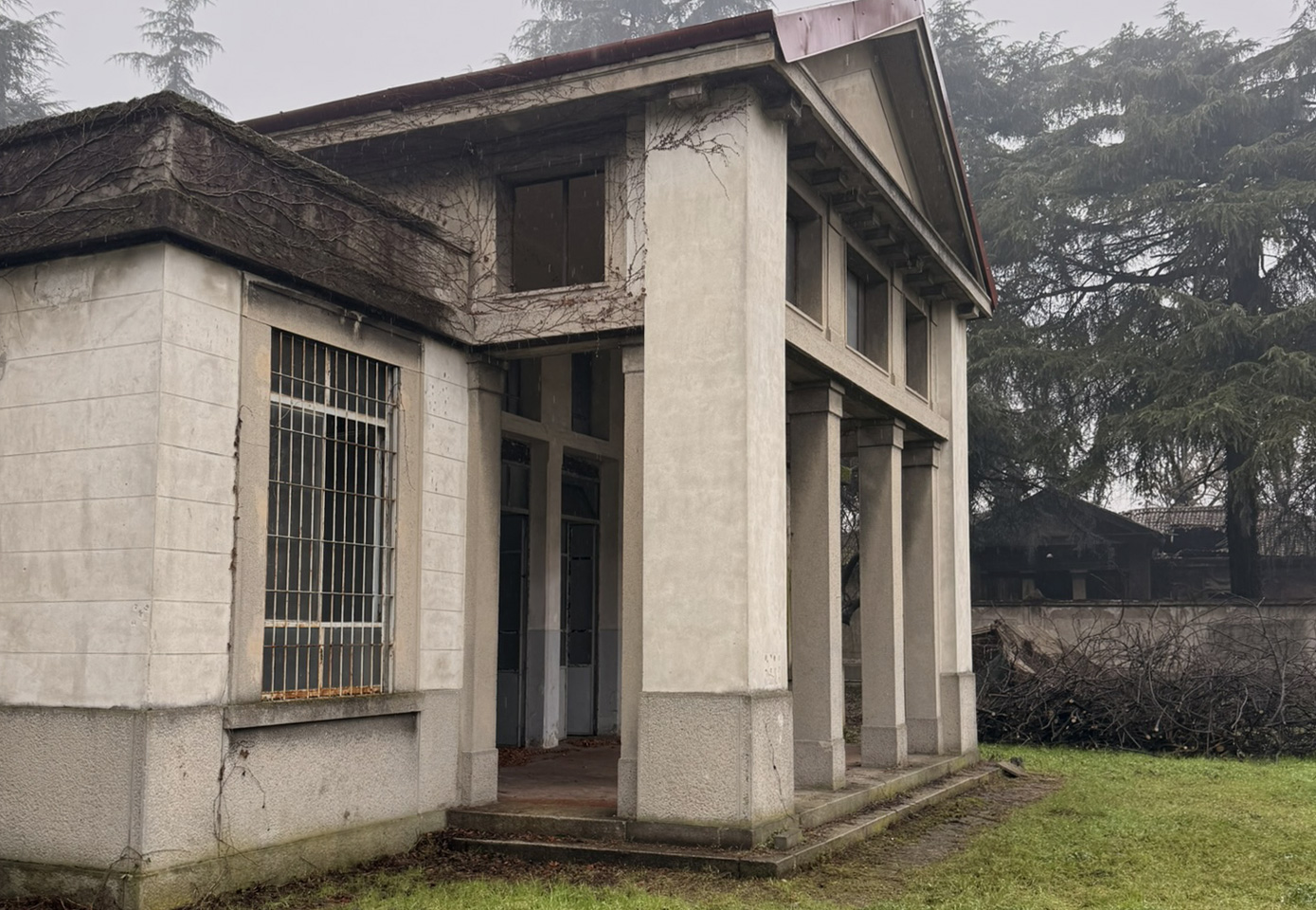 Villa storica con prato e specchio d’acqua riflettente, installazione sferica rossa al centro davanti alla facciata.