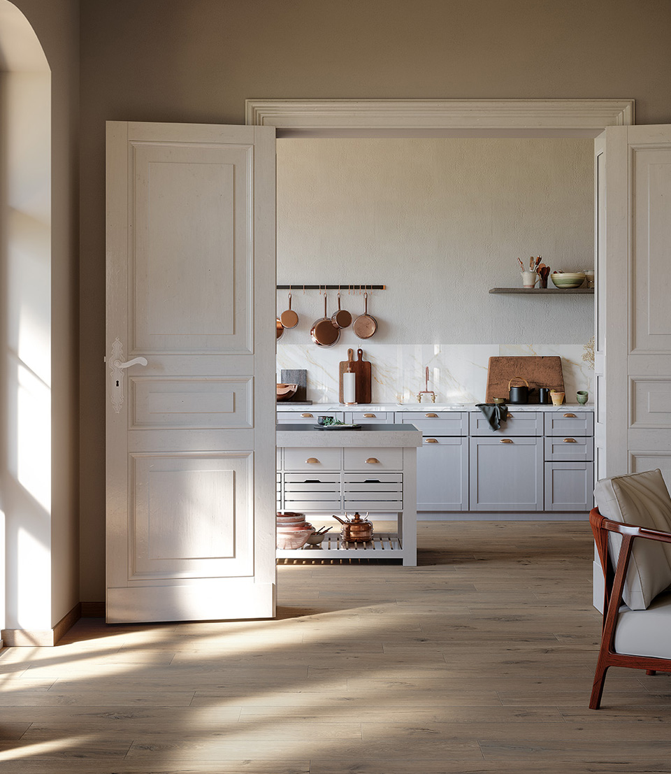 Cucina classica con pavimento in gres effetto legno chiaro, pensili bianchi, dettagli in rame e top in marmo luminoso con accessori in ceramica.