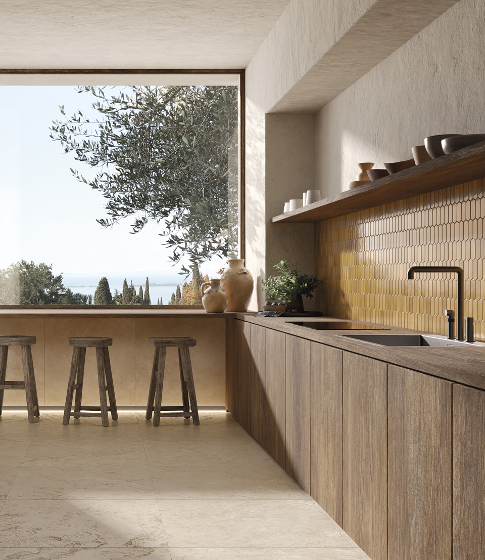 Cucina luminosa con rivestimento in piastrelle giallo miele Vento del Sud, mobili in legno e ampio affaccio sulla natura mediterranea.